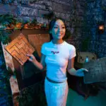 Smiling guest holding wooden maze pieces inside an adventure escape room at Escapology.